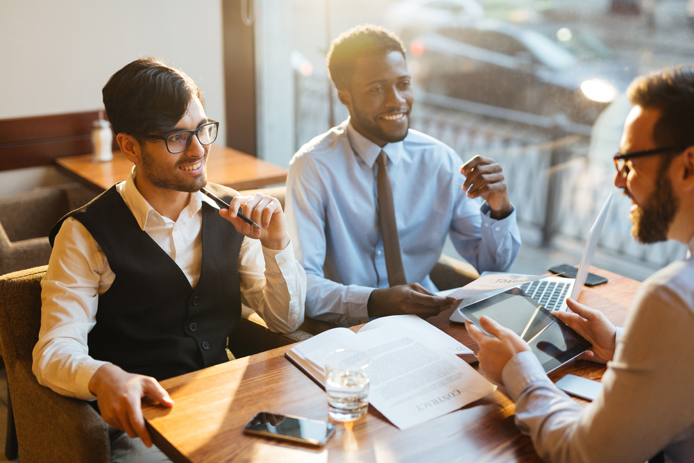 team,of,businessmen,negotiating,at,meeting,in,cafe